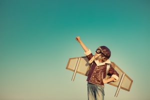 Boy with jet pack on and fist in the air and 1 hand on hip