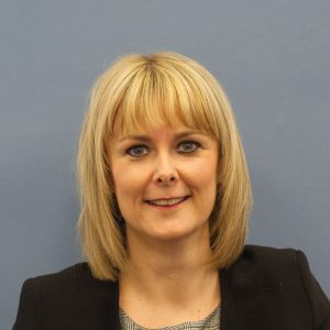 Gillian Graham, smiling against grey background